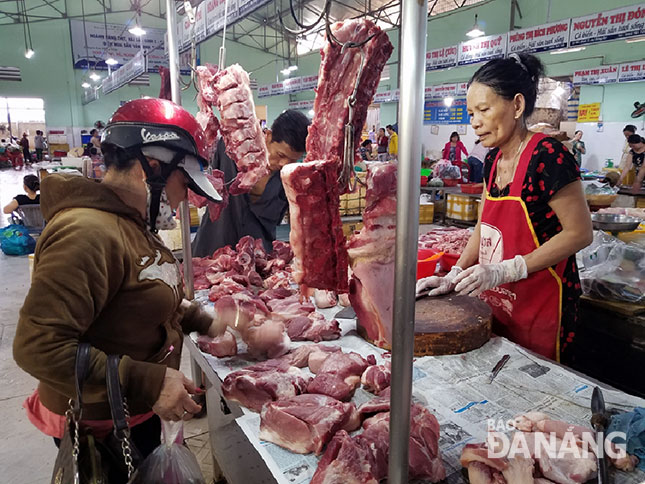 Giá thịt heo bán lẻ hiện tăng từ 10.000 -15.000 đồng/kg so với hồi đầu năm. TRONG ẢNH: Người tiêu dùng đang lựa chọn mua thịt heo tại chợ Đống Đa.