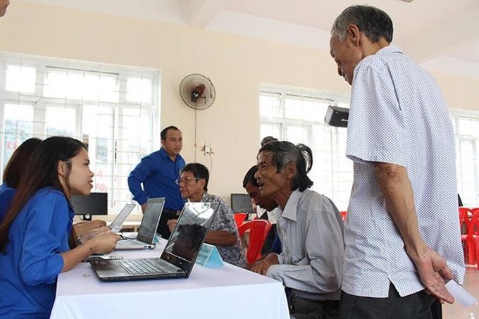 Volunteers of Đà Nẵng City’s Youth Union help local residents set up e-citizen account. — Photo tienphong.vn Read more at http://vietnamnews.vn/society/450126/lending-a-helping-hand.html#pvI3OddphUVCHZDu.99
