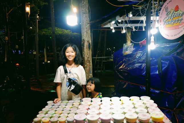 Cô chủ nhỏ Đặng Thị Thảo Linh bên quầy hàng Slime Cakess tại chợ đêm Helio. Ảnh: Mai Hiền
