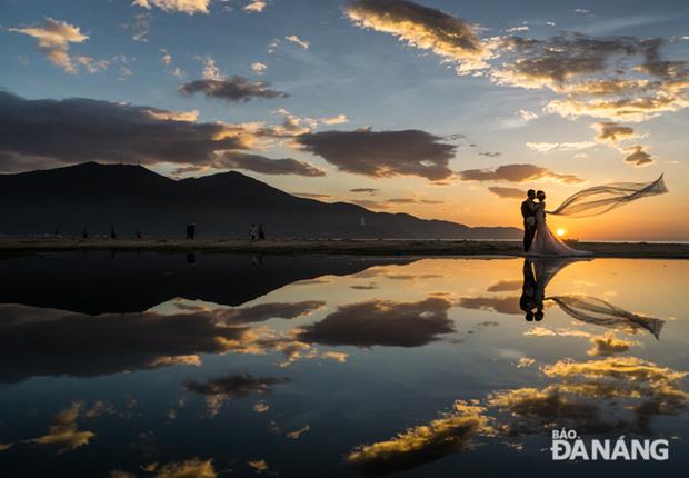 A silhouette of a couple on their wedding photo shoot on a beach