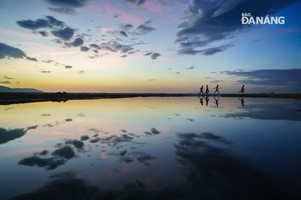 Some local people running along a beach in the early morning