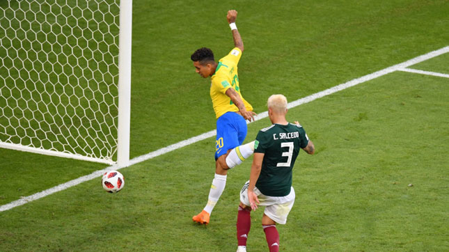 Firmino (áo vàng) với bàn thắng ấn định chiến thắng 2-0 của Brazil trước Mexico (áo xanh). 		                  Ảnh: FIFA