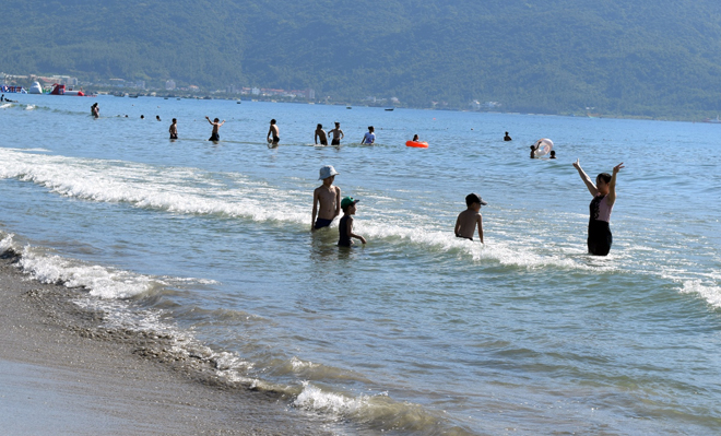 Nhiều du khách vẫn thích thú tắm biển tại bãi tắm Phước Mỹ.