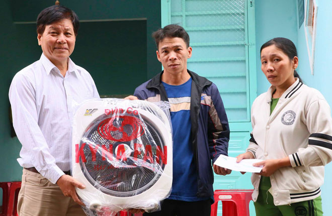 Nhà báo Vũ Công Điền (ngoài cùng, bên trái) trao tặng quà từ thiện cho nhân vật anh đã kêu gọi trên trang facebook cá nhân của mình. 