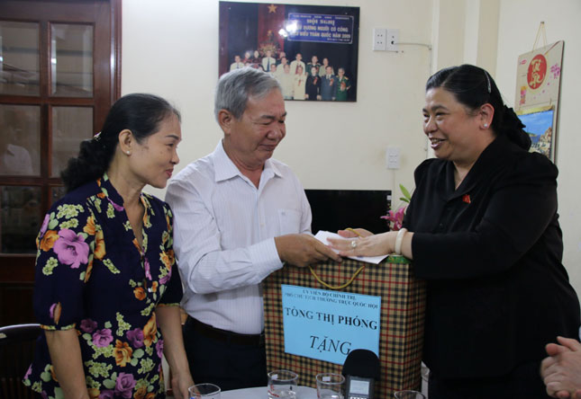 NA Vice Chairwoman Phong (right) presenting a gift to the family of war invalid Lam Van Ba