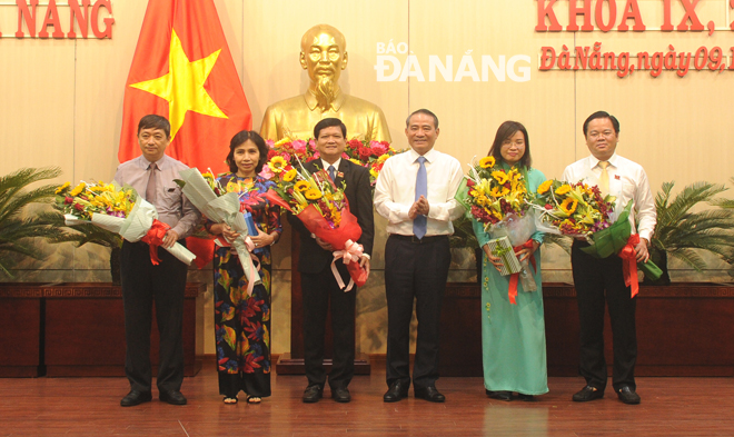 Municipal Party Committee Secretary Truong Quang Nghia ( 3rd, right) congratulating newly-elected Chairman of the municipal People’s Council Nguyen Nho Trung (3rd, left),  municipal People’s Council Vice Chairman Le Minh Trng (1st, right) and municipal People’s Committee Vice Chairman Dang Viet Dung (1st, left)