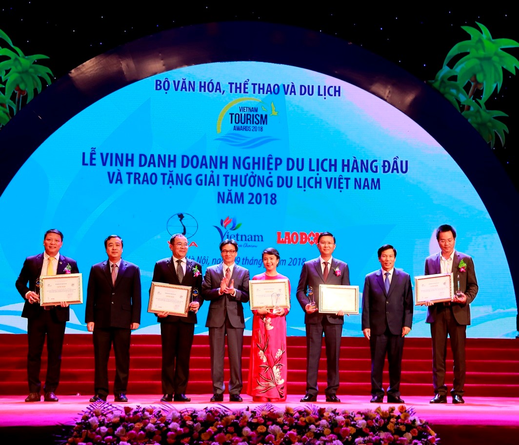 Bà Hoàng Thị Mỹ Hạnh – Phó Tổng Giám đốc Công ty cổ phần Vinpearl (áo dài đỏ) nhận giải Doanh nghiệp đầu tư và kinh doanh du lịch hàng đầu Việt Nam.
