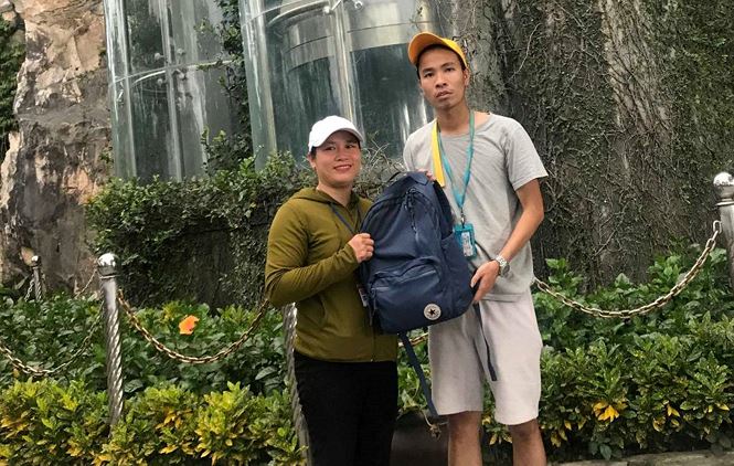 A representative from the Management Board (left) returning the backpack to Mr Trung (Photo: tienphong.vn)