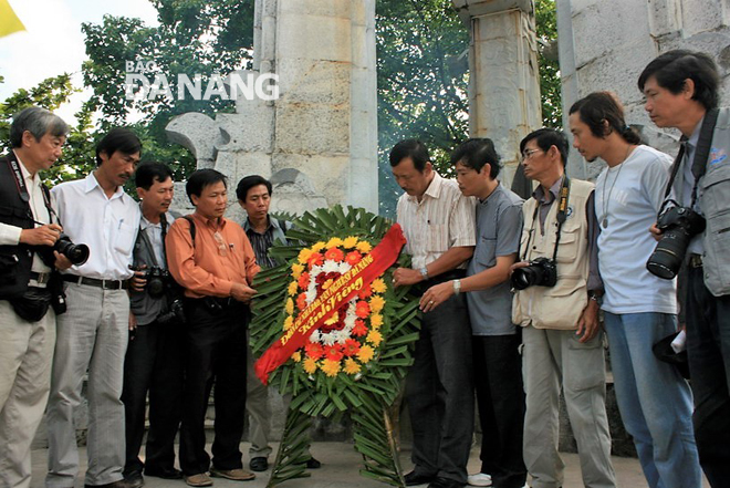 Nhạc sĩ Thái Nghĩa (thứ năm, phải qua) cùng anh em đặt vòng hoa tại Tượng đài chính ở Nghĩa trang Liệt sĩ Quốc gia Trường Sơn. Ảnh: VTL