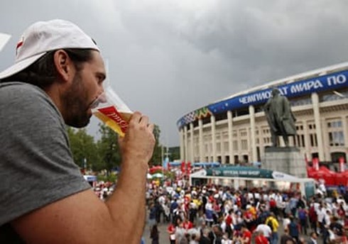 Một CĐV nhâm nhi ly bia trong lúc chờ đợi lễ bế mạc và trận chung kết diễn ra. (Ảnh: Getty)