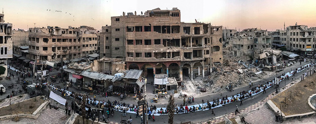 Bức ảnh hàng dài người Syria ngồi ăn tối khi tháng ăn chay Ramadan kết thúc tại thành phố Douma (Syria) trong bối cảnh xung quanh bị tàn phá nặng nề bởi chiến tranh. Bức ảnh được Mohammed Badra (Syria) chụp bằng iPhone 7 đã giành giải nhất trong hạng mục ảnh “Tin tức/Sự kiện”.