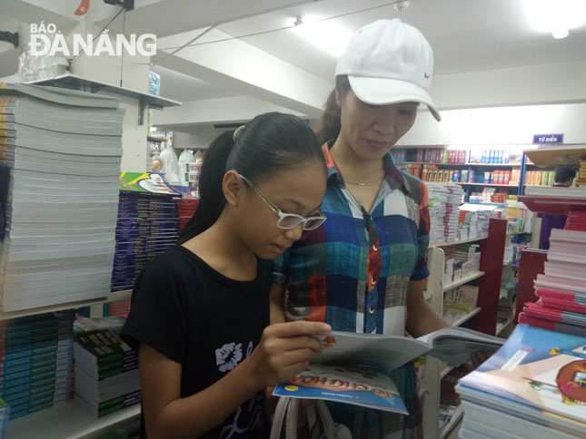 Chị Phạm Thị Yến (ở huyện Đại Lộc, tỉnh Quảng Nam) chọn sách cho con ở Nhà sách Đà Nẵng.