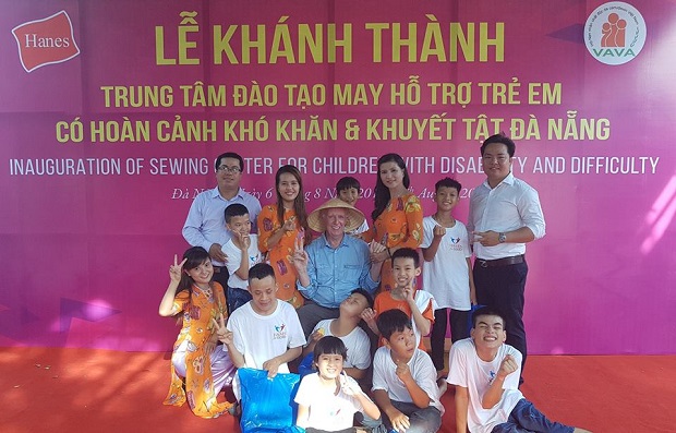 Mr Matthew Keenan (wearing Vietnamese conical hat) posing for a souvenir photo with AO-affected children at the recent inauguration ceremony for the sewing training facility