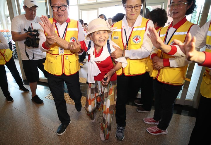 Các nhân viên Hội chữ thập đỏ Hàn Quốc đang giúp đỡ một cụ già 92 tuổi chuẩn bị cho cuộc đoàn tụ gia đình. Ảnh: Yonhap.