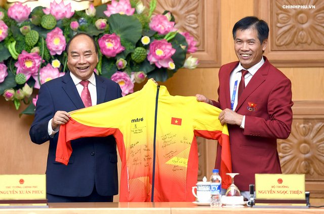 Thủ tướng nhận quà kỷ niệm là chiếc áo đấu có chữ ký của các cầu thủ đội Olympic Việt Nam