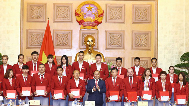 Thủ tướng Nguyễn Xuân Phúc (giữa, hàng trước) tặng quà cho Trưởng đoàn Thể thao Việt Nam và các thành viên, đại diện cho các HLV, VĐV xuất sắc tham dự ASIAD 2018. Ảnh: TTXVN