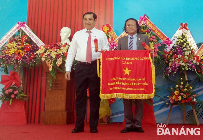 Chủ tịch UBND thành phố Huỳnh Đức Thơ trao cờ ghi nhận 40 năm xây dựng và phát triển Trường THPT Trần Phú.   Ảnh: PHƯƠNG MINH