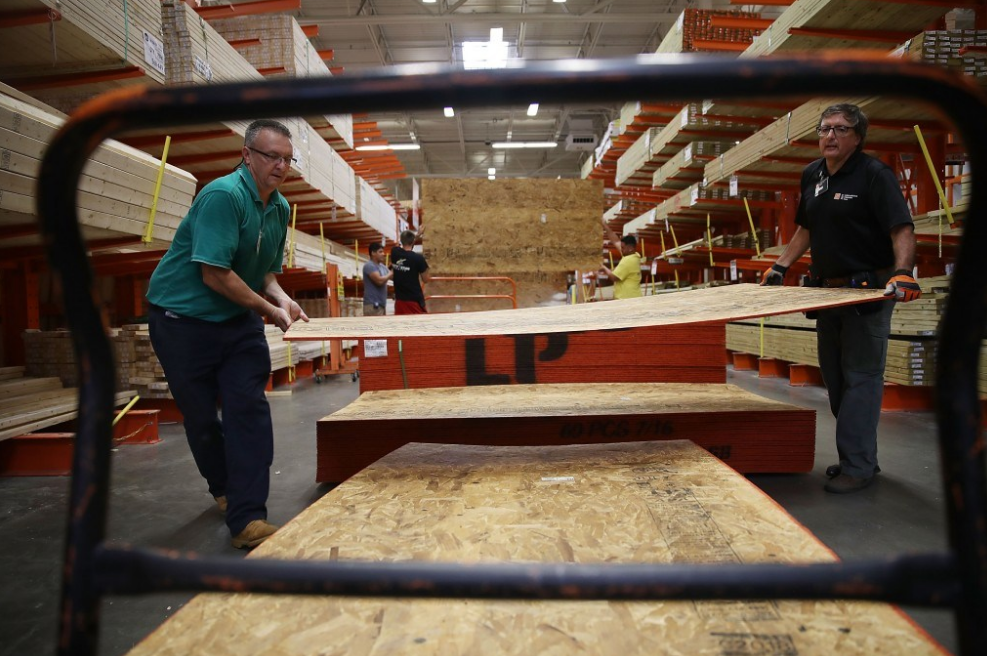 Nhân viên đồ gỗ giúp khách hàng vận chuyển những tấm ván để che chắn gió bão. Ảnh: Getty Images