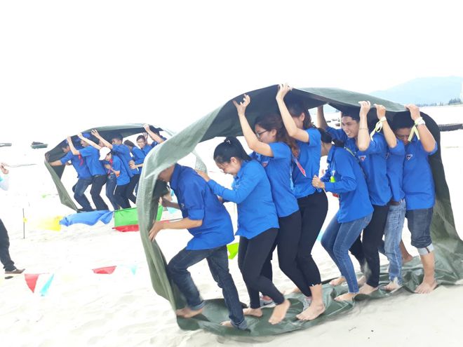 Thành viên trong mỗi đội phối hợp với nhau nhịp nhàng, khéo léo để hoàn thành phần thi “Bánh xe thần tốc” tại trạm cuối: biển Nguyễn Tất Thành. (Ảnh do Bảo tàng Đà Nẵng cung cấp)