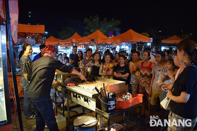 A chef performing Japanese-style rice flour pancakes in the Son Tra Night Market