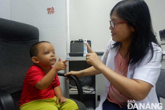 Nhiều trẻ hồi phục thị lực sau khi phẫu thuật miễn phí những dị tật ở mắt. Trong ảnh: Bác sĩ Hồ Thị Ngọc khám và tập điều chỉnh hướng nhìn cho một bệnh nhi vừa được phẫu thuật.