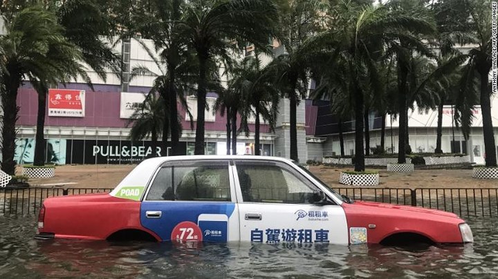 Chiếc xe taxi “bơi” trong biển nước trên đường phố Hong Kong. Ảnh: AFP/Getty.