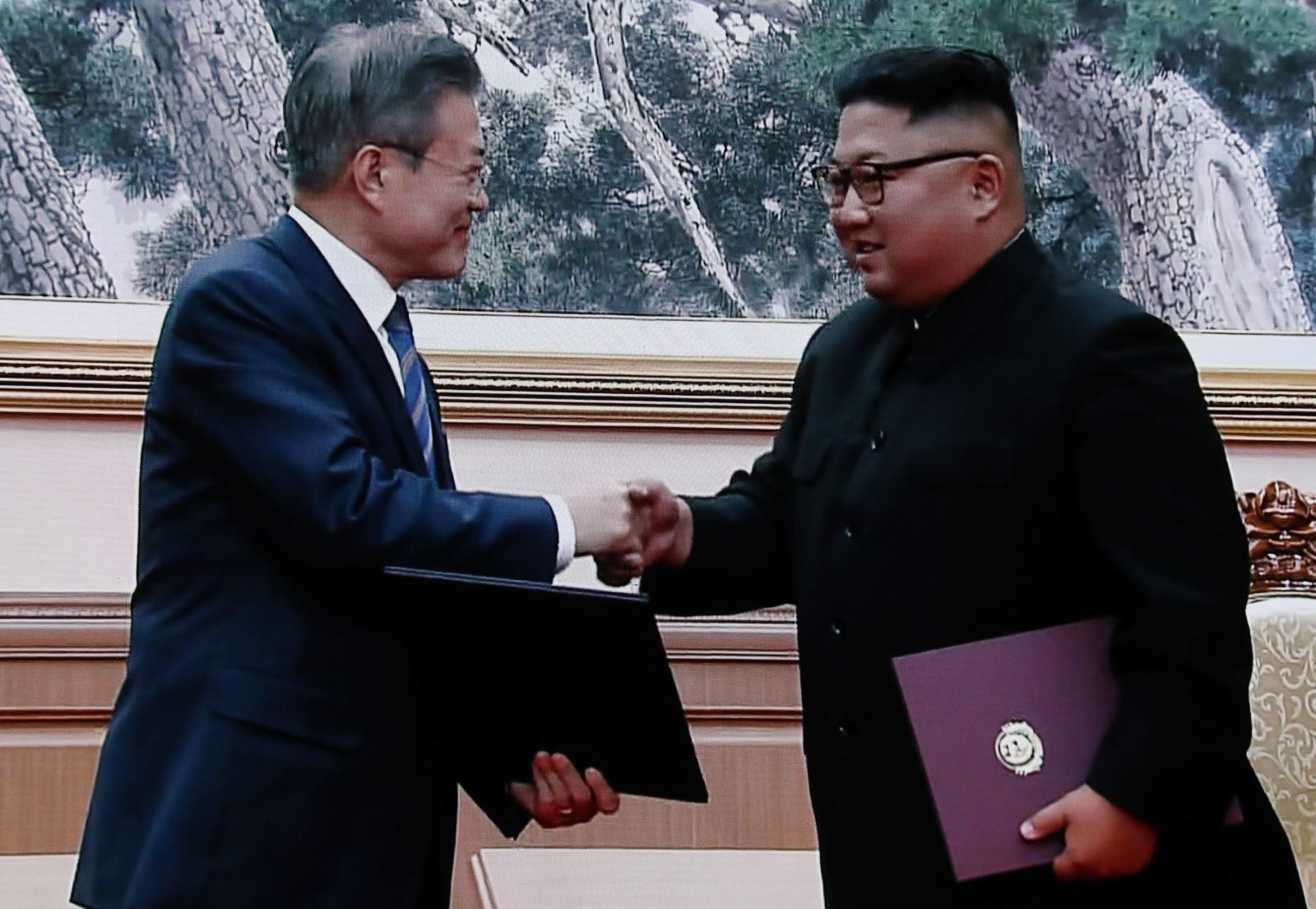 Nhà lãnh đạo Triều Tiên Kim Jong-un (phải) và Tổng thống Hàn Quốc Moon Jae-in trao đổi văn kiện sau lễ ký một thỏa thuận tại ngày hội đàm thượng đỉnh thứ hai ở Bình Nhưỡng, ngày 19/9/2018. Ảnh: YONHAP/TTXVN