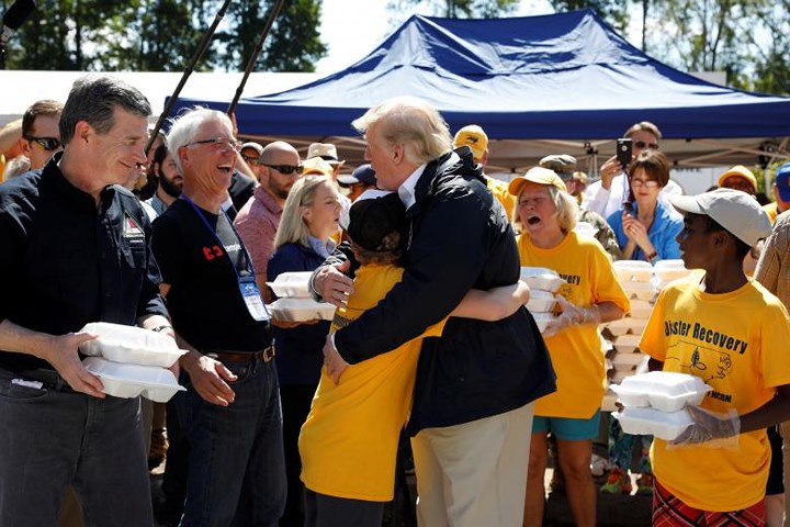 Tổng thống Trump ôm một cậu bé là tình nguyện viên phân phát đồ ăn cho người dân tại trung tâm phân phát đồ ăn ở New Bern, Bắc Carolina.