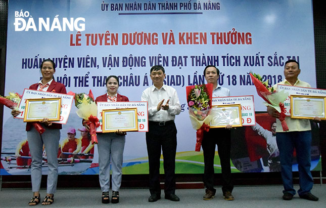 Phó Chủ tịch Thường trực UBND thành phố Đặng Việt Dũng (giữa) trao Bằng khen của UBND thành phố cho các VĐV đạt thành tích xuất sắc tại ASIAD 2018.  Ảnh: ANH VŨ