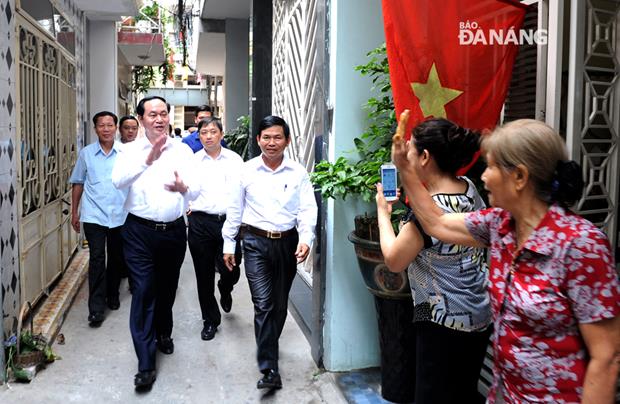 The late President waving hello with hand to residents residing in an alley on Nguyen Thai Hoc Street.