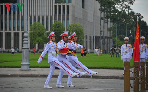 Các sĩ quan thuộc Bộ Tư lệnh Bảo vệ Lăng Chủ tịch Hồ Chí Minh mang theo dải băng tang để buộc vào lá cờ Tổ quốc.
