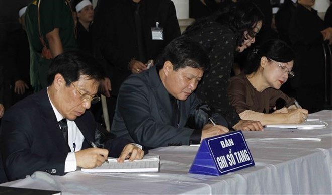 Bộ trưởng Bộ Văn hóa, Thể thao và Du lịch Nguyễn Ngọc Thiện (bên trái) ghi sổ tang. Ảnh: TTXVN