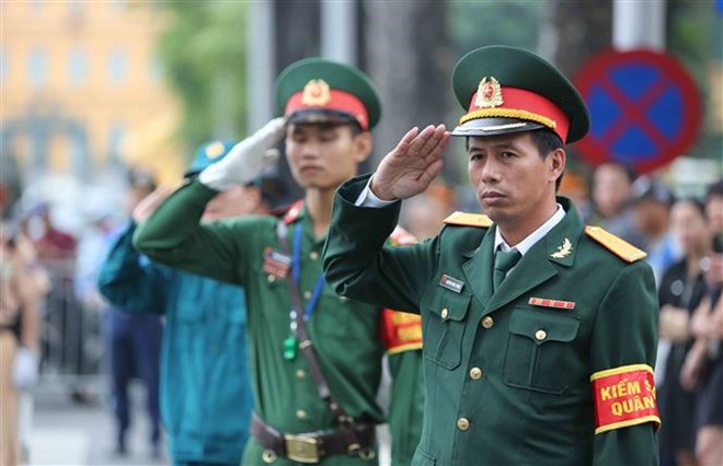 Cán bộ, chiến sĩ lực lượng vũ trang thực hiện nghi thức khi xe đưa linh cữu Chủ tịch nước Trần Đại Quang đi qua. Ảnh: TTXVN