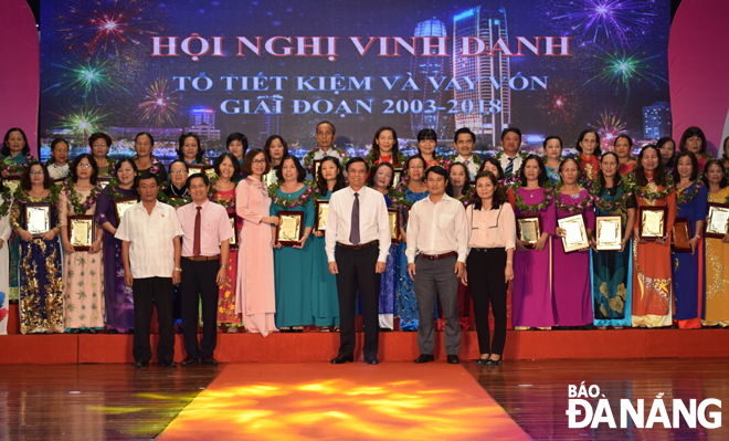 Phó Chủ tịch UBND thành phố Trần Văn Miên (giữa) trao bằng khen cho các tổ trưởng tổ tiết kiệm và vay vốn. 
