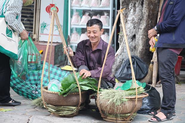 A middle-aged man selling ‘Com’ (green sticky rice) from the Vong Village at a corner of Hang Than Street