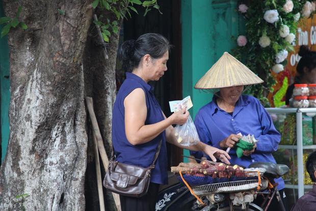 A woman selling sweet potatoes on an old bicycle