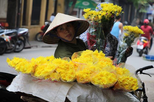 A street vendor carrying flowers for sale