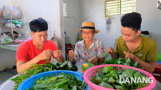 Các sinh viên tại Mái ấm Nam sinh viên Hal’s Home phụ bảo mẫu Nguyễn Thị Minh chuẩn bị bữa trưa cho cả mái ấm. Ảnh: K.Q