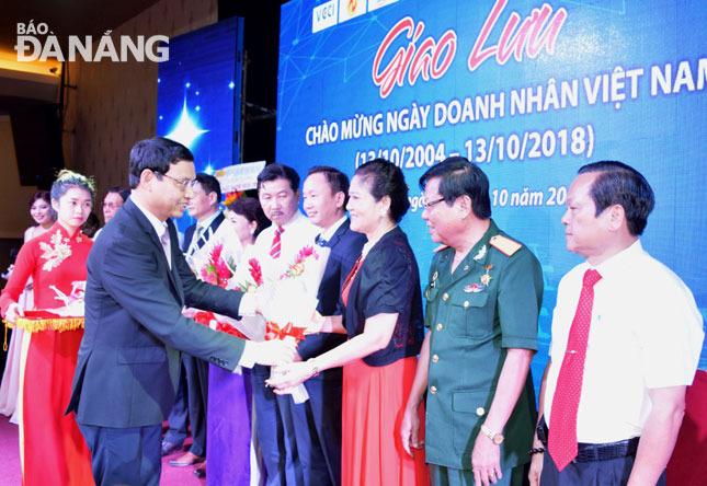 Phó Chủ tịch UBND thành phố Hồ Kỳ Minh (bìa trái) tặng hoa và chúc mừng cộng đồng doanh nghiệp, doanh nhân nhân Ngày Doanh nhân Việt Nam. 		    Ảnh: HOÀNG HIỆP