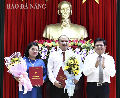 Phó Bí thư Thường trực Thành ủy Võ Công Trí (bìa trái) trao quyết định và tặng hoa cho bà Huỳnh Thị Tam Thanh và ông Lê Quang Nam.