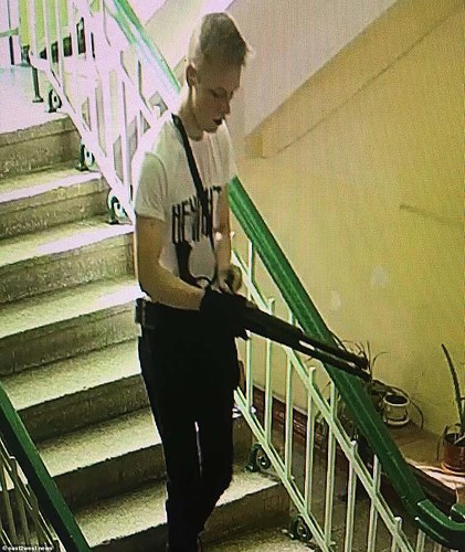 Hình ảnh trích xuất từ camera cho thấy, nghi phạm Vladislav Roslyakov, còn khá trẻ, mới 18 tuổi, mặc một chiếc áo phông trắng với dòng chữ đen và đeo khẩu súng lớn, bước xuống cầu thang. Ảnh: East2west news.
