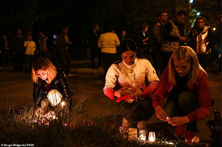 Mọi người thắp nến tưởng niệm các nạn nhân bị thiệt mạng quanh khuôn viên trường cao đẳng ở Kerch, Crimea sau vụ xả súng. Ảnh: TASS.