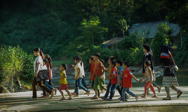 Teachers and Dao Tien pupils going to their school