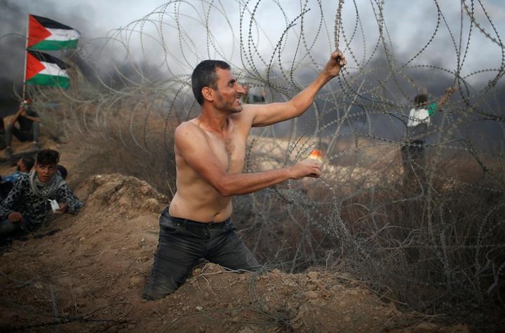 Một người khuyết tật Palestine đang cố phá hàng rào phong tỏa tại biên giới Dải Gaza với Israel.