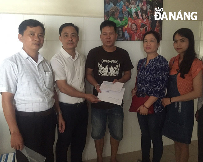 The Department’s representatives handing over the donations to Nhi’s father (centre)