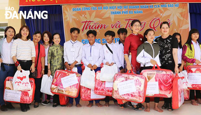 Đại diện Hiệp hội Nữ doanh nhân và Câu lạc bộ Nhà báo nữ thành phố Đà Nẵng tặng quà cho học sinh Trường THPT Võ Chí Công.  Ảnh: T.N