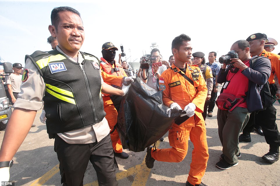 Lực lượng cứu hộ khiêng một túi đựng xác. Ảnh: AFP