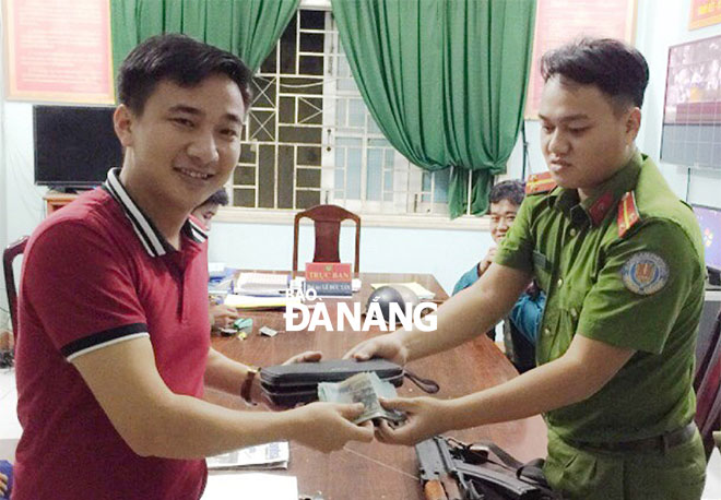 A police officer from Hoa Thuan Tay Ward (right) returning the lost property to Mr Manh