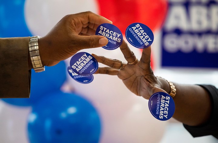 Những người ủng hộ bà Stacey Abrams - ứng viên đảng Dân chủ tranh cử cho vị trí Thống đốc bang Georgia, đang phát các miếng dán cổ động cho mọi người trong một cuộc mít tinh vận động bỏ phiếu ở Savannah. 
