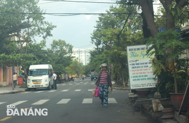 Vỉa hè trước số nhà 55 An Hải 17, phường An Hải Bắc (quận Sơn Trà) bị chiếm dụng để biển quảng cáo, chậu cây cảnh, người đi bộ phải đi xuống lòng đường.